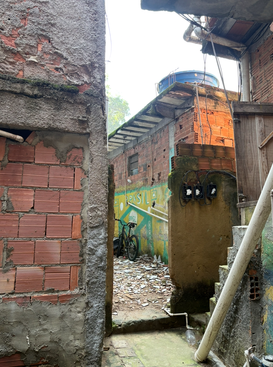 Abitazioni di comunità sudamericane ai margini della società, tra architettura incompleta e soluzioni di fortuna per la sopravvivenza quotidiana.